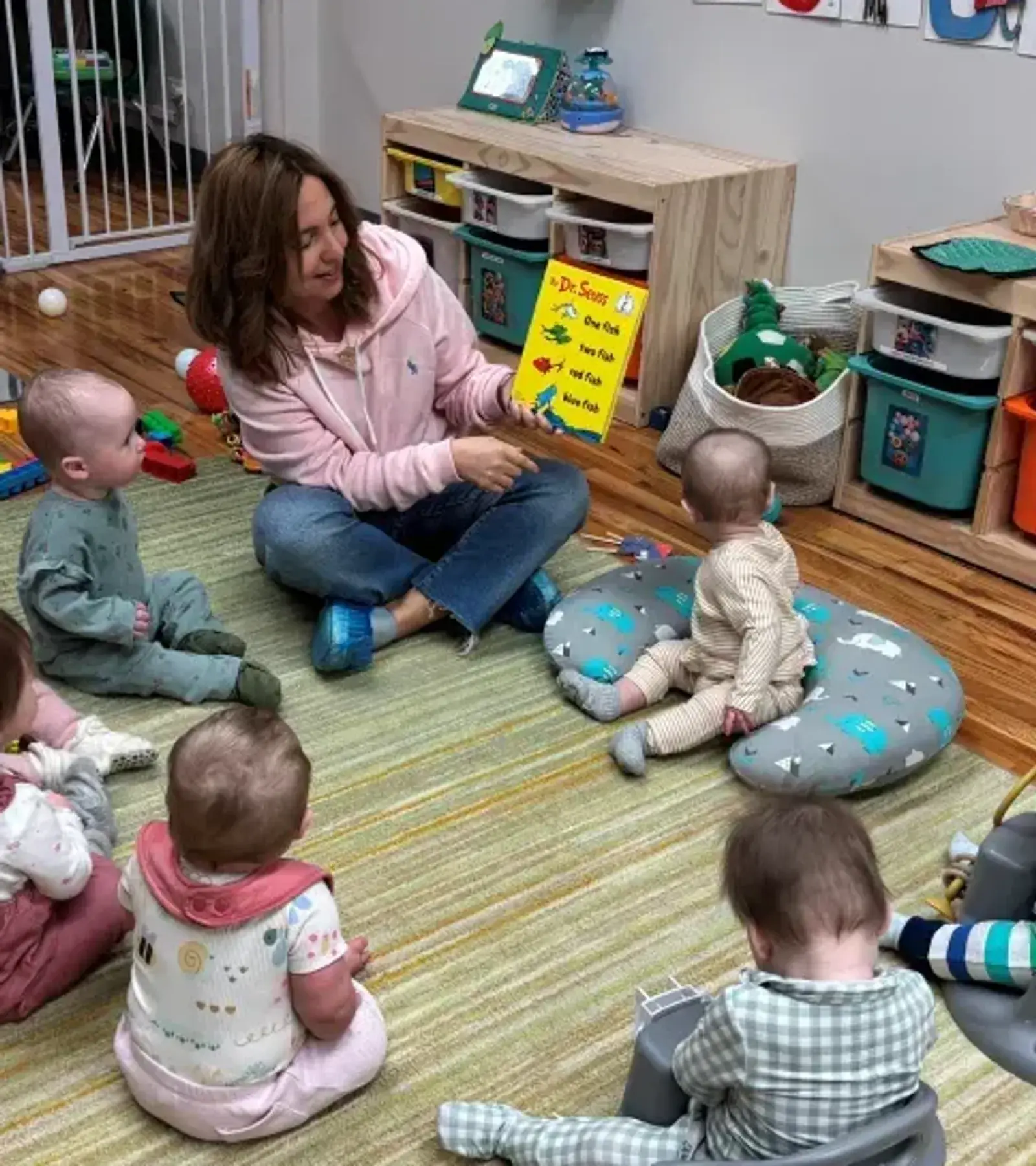 Songbird Academy teacher reading a picture book to a circle of infants in a Chicago classroom